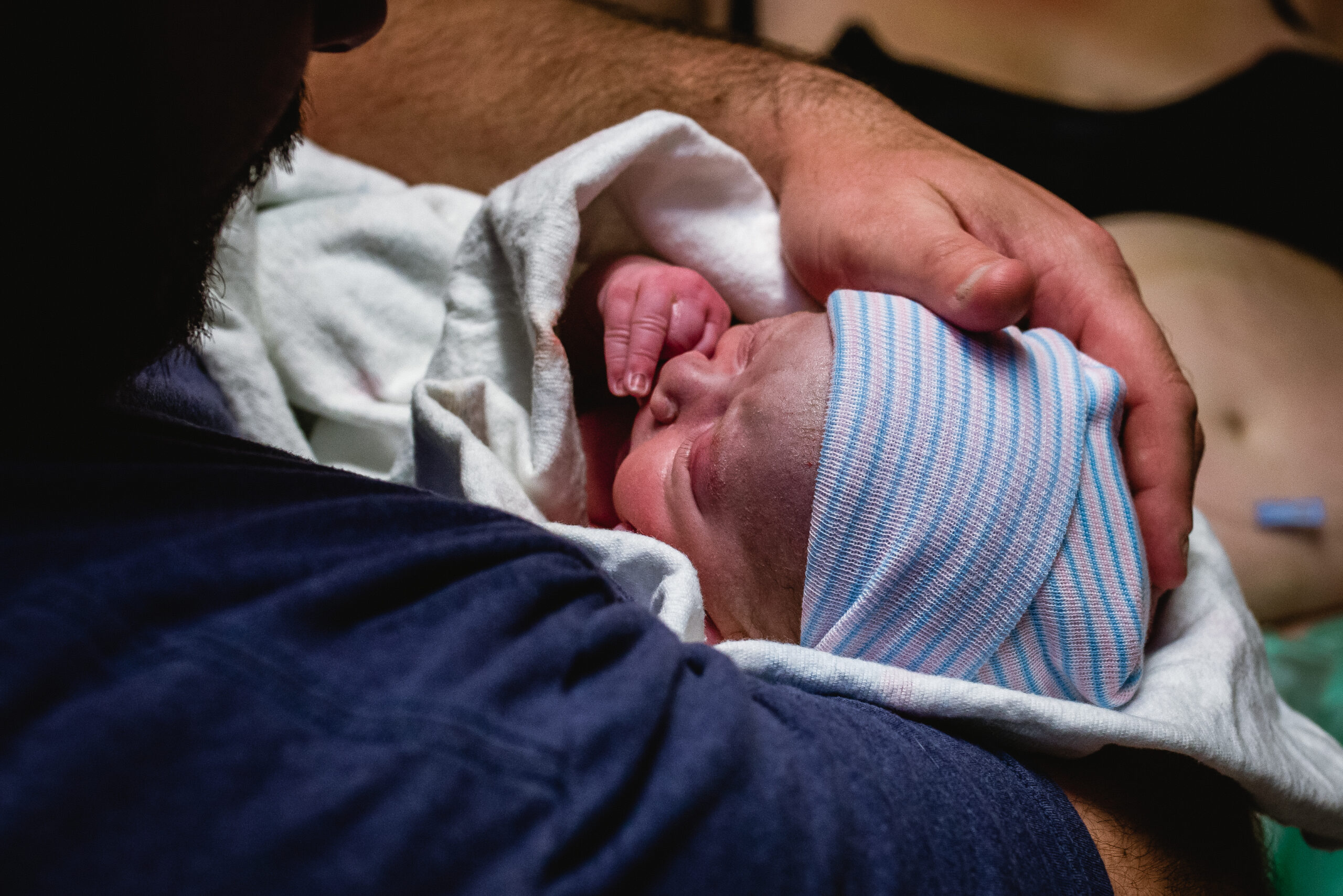 Father holding his newborn son after birth Wilmington NV Birth Photographer